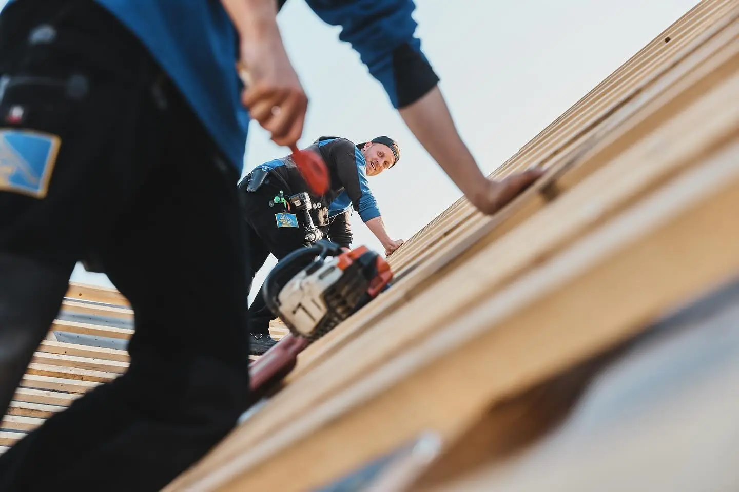 Dachdecker Yannick Twistel von der Dachdeckerei Twistel in Bielefeld bei der Montage von Holzlatten auf einem geneigten Dach.
