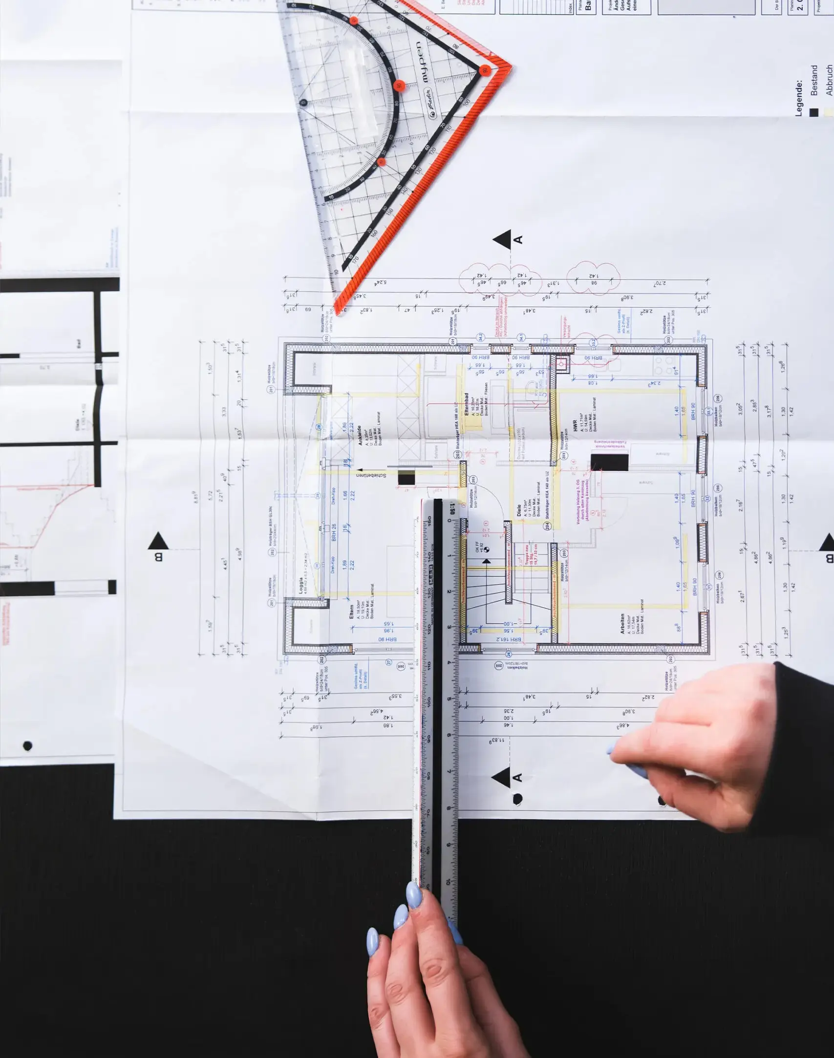 Technische Bauzeichnung mit Lineal und Geodreieck, Hände markieren Maße, Symbol für Planung und Beratung bei Konstruktiv Plus in Bielefeld.